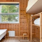 Room with wooden walls, bunk bed, window, and ladder.