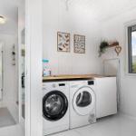 Washing room with washing machine, dryer, and window.