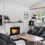 Living area with fireplace, TV, and dining space. Kitchen with countertop and window.