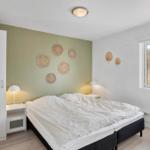 Schlafzimmer mit Doppelbett, Nachttischen und Fenster zum Blick auf die Landschaft.