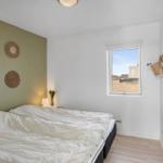 Schlafzimmer mit Bett, Fenster und Wanddekoration.
