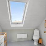 Badezimmer mit Dachfenster, Toilette und Waschbecken.