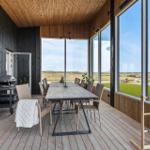 Terrasse mit Esstisch, Grill und Blick auf Felder.