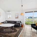 Wohnzimmer mit Sofa, Tisch und Blick auf Grasland.
