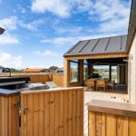 Terrasse mit Grill, Sitzgelegenheiten und Blick auf die Umgebung.