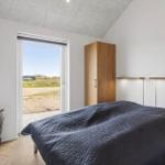 Schlafzimmer mit Bett, Schrank und Blick auf Außenbereich.