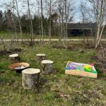 Außenbereich mit Holzstümpfen und Sandkasten für Kinder.