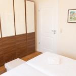 Schlafzimmer mit Bett, Kleiderschrank und Wandbild.