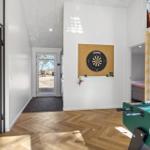 Raum mit Dartboard, Foosballtisch und Schlafbereich mit Leiter.
