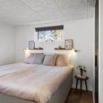 Schlafzimmer mit Bett, Fenster und kleinem Tisch