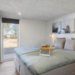 Schlafzimmer mit Bett, Fenster und Wandbildern von Seehunden.