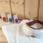 Massagegerät und Duftöle auf Holzbank