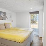 Schlafzimmer mit Bett, Wandbildern und Fenster zur Außenseite.