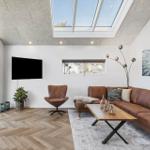 Wohnzimmer mit braunem Sofa, Holzfußboden und Dachfenster.