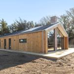 Moderne Holzhütte mit großem Glasbereich und Terrasse im Wald