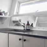 Sink with mirror and window above countertop