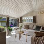 Wohnzimmer mit Sofa, Tisch und Blick auf Garten.