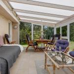 Terrasse mit Sofa, Sitzgruppe und Tisch unter Dach