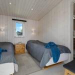 Zwei Betten, Fenster, Nachttisch, Bad mit Waschbecken und Toilette.