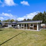 Moderne Ferienhaus mit großem Garten und überdachtem Bereich.