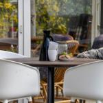 Ein Tisch mit Stühlen und Früchten vor einem Fenster mit Blick auf den Garten.