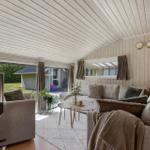 Wohnzimmer mit Sofa, Tisch und Blick auf Garten