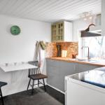 Kitchen with dining area, colorful tiles, and modern equipment.
