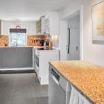 Kitchen with countertop, refrigerator, and tile backsplash