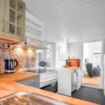 Kitchen with wooden countertop, glass-front cabinet, and colorful tiles on the wall.