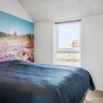 Bedroom with bed, wall mural, and window view of outdoor area.