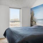 Bedroom with bed, window, and wall mural of beach