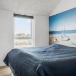 Bedroom with bed, window, and wall mural of boats on beach.