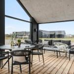 Terrace with seating group, table and chairs. Large glass front with view of outdoor area.
