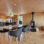 Dining room with table, chairs, and fireplace in wooden house.