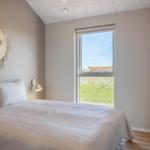 Schlafzimmer mit Bett, Fenster und Wanddekoration.