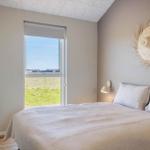 Schlafzimmer mit Bett, Fenster und Wanddekoration