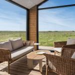 Terrasse mit Rattanmöbeln und Blick auf eine grüne Landschaft.