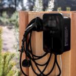 Elektrische Ladestation an Holzwand im Wald