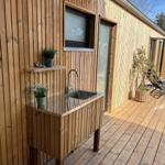 Außenküche mit Edelstahlsink und Holzoberfläche an Holzwand