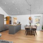 Moderne Küche mit Essbereich und Holzboden. Große Fenster und Deckenleuchte.