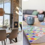 Esszimmer mit Holztisch, Stühlen und Kamin. Spielkarten und Tassen auf Tisch.