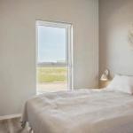 Schlafzimmer mit Bett, Fenster und Wanddekoration