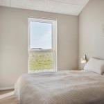 Schlafzimmer mit Bett, Fenster und Wanddekoration.