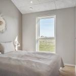 Schlafzimmer mit Bett, Fenster und Wanddekoration.