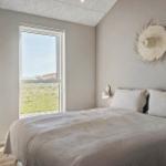 Schlafzimmer mit Bett, Fenster und Wanddekoration.