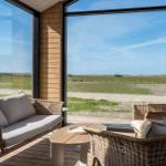 Terrasse mit Sitzgruppe und Blick auf Grasland und Himmel.