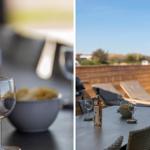 Tisch mit Wein und Chips auf Terrasse mit Liegen und Blick auf Landschaft.