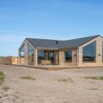 Moderne Holzhütte mit großem Glasbereich und Terrasse im Sand