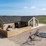Moderne Ferienhaus mit Whirlpool, Spielplatz und Trampolin auf freiem Grund.