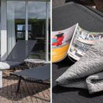 Terrasse mit Liegestühlen und Zeitschriften. Blick in das Haus durch Glastüren.